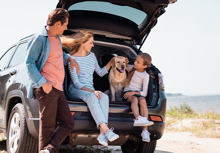 Family enjoying a beach trip with a rental vehicle from Step One Car Rental in Fort Walton Beach, FL