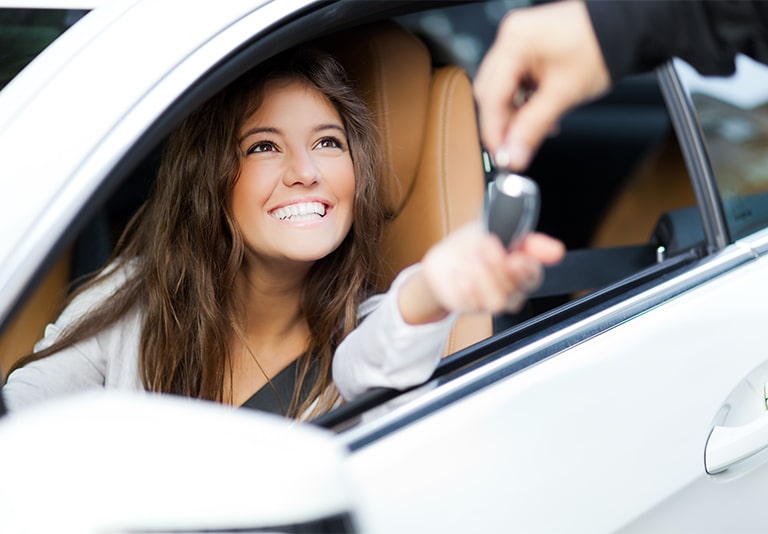 Smiling customer receiving keys for a minivan rental from Step One Car Rental in Fort Walton Beach, FL